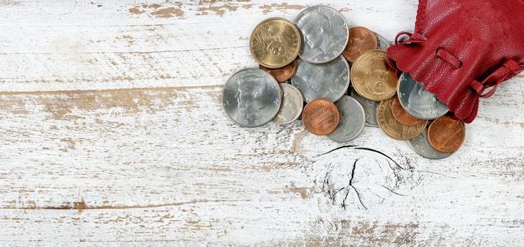 Bag of United States coins on white rustic wood