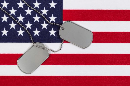 Flag of the United States of America with military identification tags and neck chain.