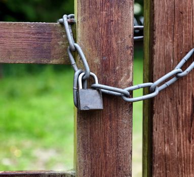 Key lock and thick chain on fence post