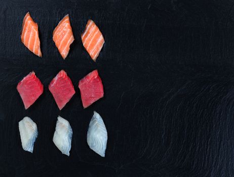 Overhead view of fresh Japanese sushi on black slate. Horizontal layout with plenty of copy space. 