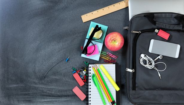 Back to School with modern technology and traditional items on chalkboard background