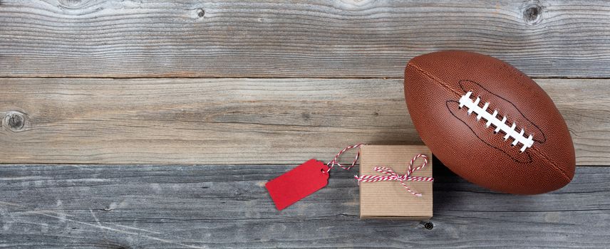 Fathers day gift box with football on vintage wooden plank background