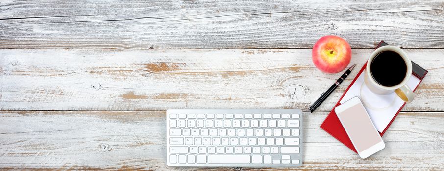 Top view of a functional desktop with various office equipment and snack foods 