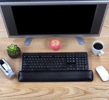 Overhead view of office technology on wooden red oak desktop  