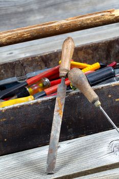 Vertical image of old tool box filled with tools on rustic wooden boards