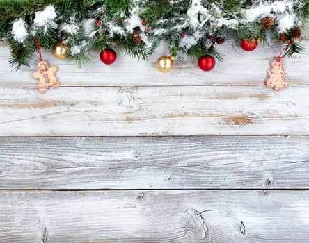 Christmas evergreen branches with other holiday decorations on white rustic wood