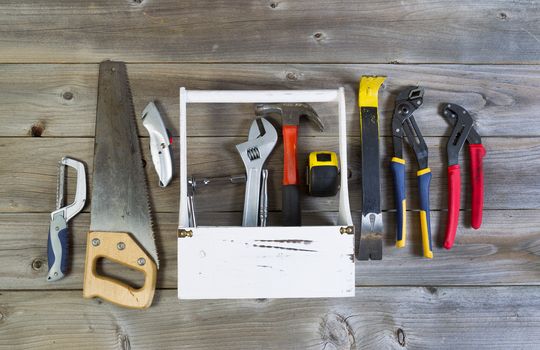 Over head view of basic home repair tools and holder on rustic wooden boards