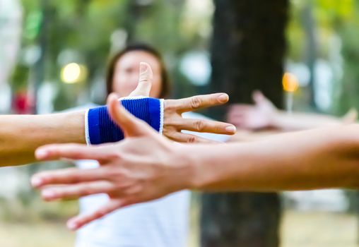 hands of people are raised up yoga in the park outdoor