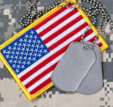 American flag and dog tags on camouflage background