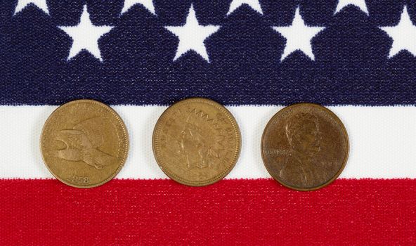 Closeup view of United States One Cent Pieces, original start dates, placed on American Flag 