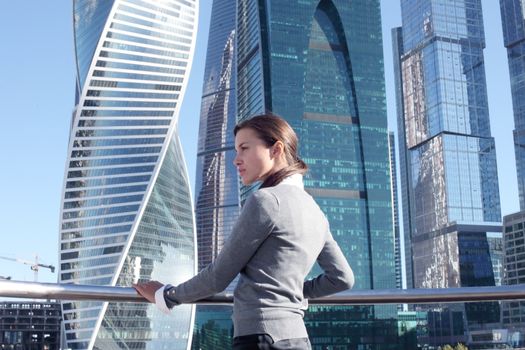 Stressed business woman in the city over skyscrapers background