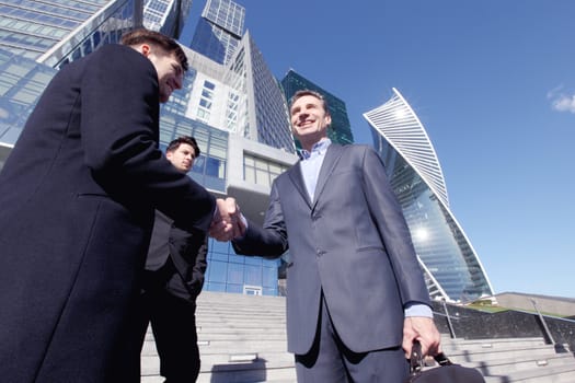 Business people shaking hands at meeting outdoors, finishing up a meeting