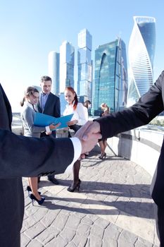 Business people shaking hands at meeting outdoors, finishing up a meeting