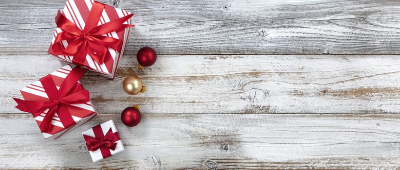 Merry Christmas with gifts and ball ornaments on white rustic wooden background for the holiday