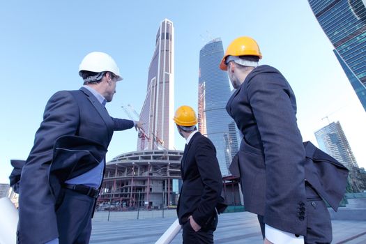 Engineering and architecture concept, engineers working on a building site holding blueprints , architects and engineers inspection in workplace for architectural plan