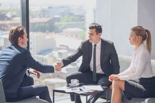 Interviewer shaking hand of an interviewee during a job interview in office
