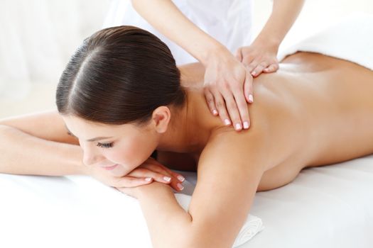 Smiling woman enjoying a massage in a spa center