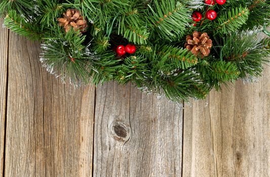 Christmas border with decorative wreath on rustic wooden boards. 