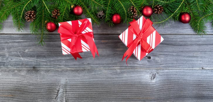 Overhead view of real fir Christmas tree branches with gifts on weathered wood  