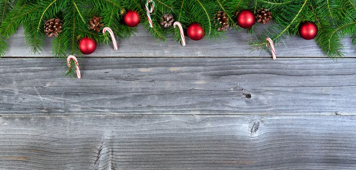 Overhead view of real fir Christmas tree branches with decorations on weathered wood  