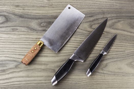 Butcher, paring and large knife set on fading white ash wood 