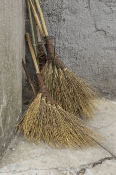 Traditional Chinese brooms against stone wall 