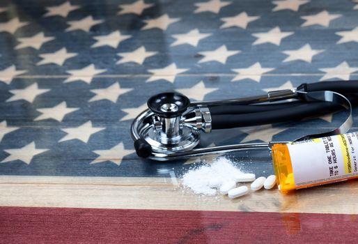 prescription for Hydrocodone or generic opioid with crushed or whole pain killer tablets. Rustic USA flag and medical stethoscope in background for drug addiction concept in America  