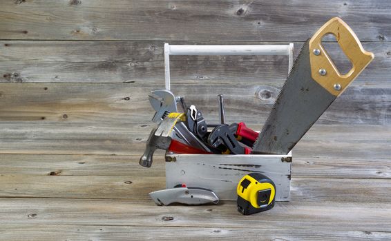 Horizontal view of an old tool holder containing basic home repair tools on rustic wooden boards