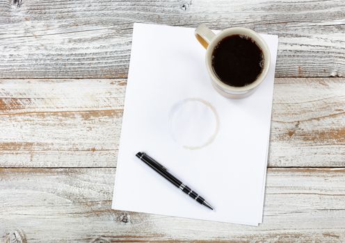 Top view of desktop with paper, pen and coffee to include stain 