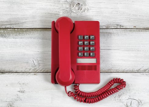 Vintage red phone on rustic white wooden boards. High angled view. 