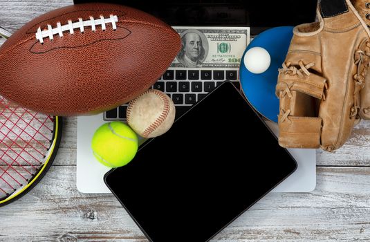 Overhead view of sports equipment with computer technology and money for betting concept 