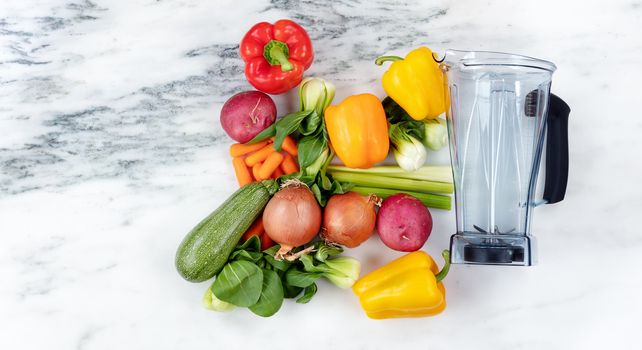 Raw organic vegetables and blender on marble stone background for healthy diet drink concept