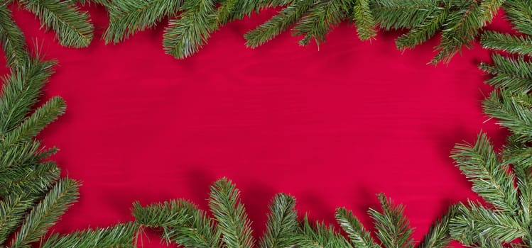 Red cloth, showing wood grain underneath, with complete evergreen border. 