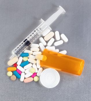 Prescription bottle with pills and syringe in overhead view