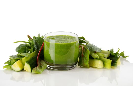 Fresh organic smoothie surrounded by vegetables isolated on white background with reflection 