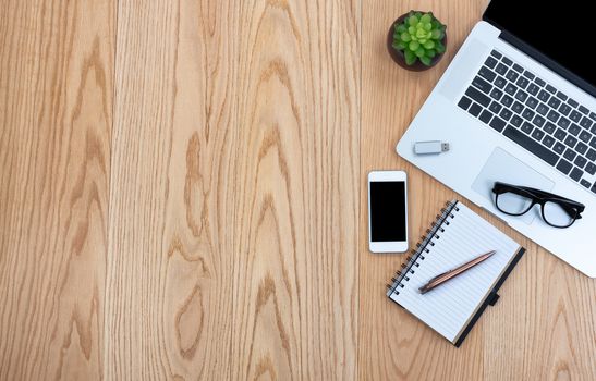 Basic office technology and writing stationery on wooden desktop  