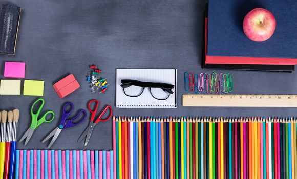 Overhead view of back to school positioned on erased chalkboard. 