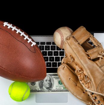 Sports equipment with computer and money for betting concept 