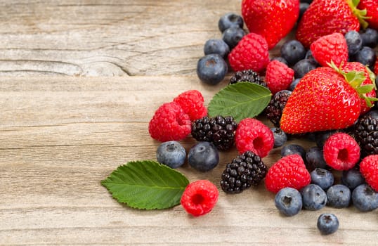 Close up of fresh berries on aged wooden boards.  