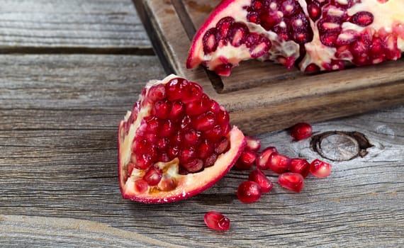 Close up of juicy ripe pomegranates vintage wood 