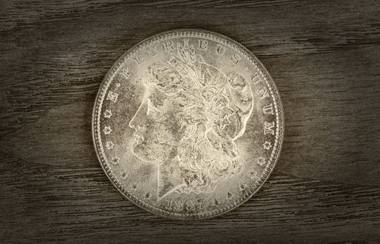 Vintage concept of a Silver Dollar in very good condition on aged wood. Slight vignette border around coin. 