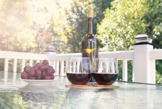 Glasses of red wine on outdoor table during summer