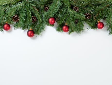 Christmas tree branches and ornaments on white background. Plenty of copy space available. 