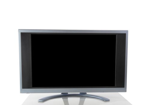 Large computer screen monitor isolated on white background with reflection on table