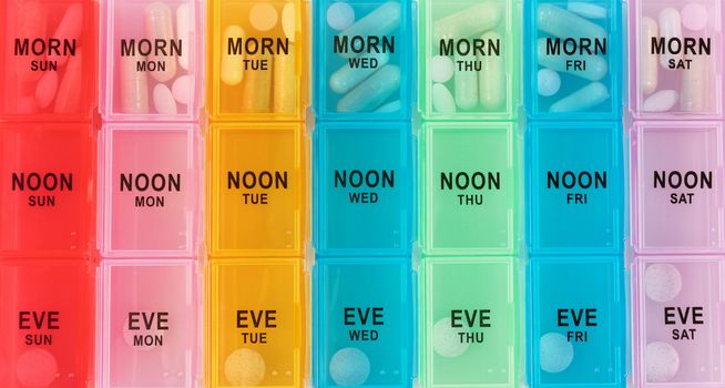 Medicine with prescription and alternative pills in daily reminder container 
