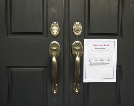 House with for rent sign on front door with brass handles