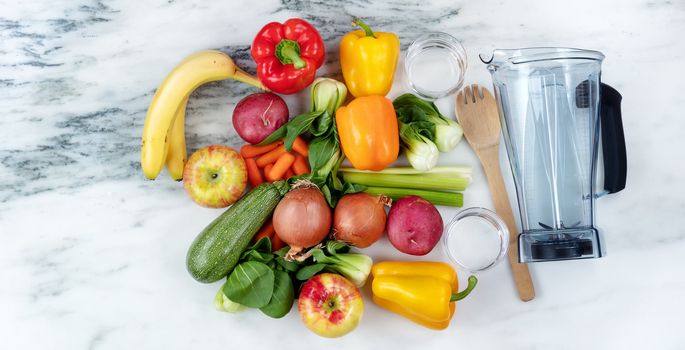 Raw organic vegetables and fruits with blender on marble stone background for healthy diet drink concept