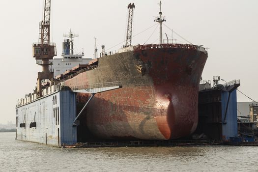 Old Cargo ship docked for hull maintenance in Chinese Harbor 