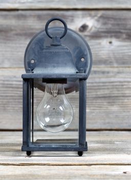 Vertical image of old outdoor light on rustic wooden boards