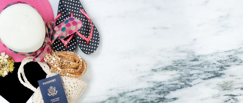 Women travel clothes with passport on marble stone forming left border in overhead view 